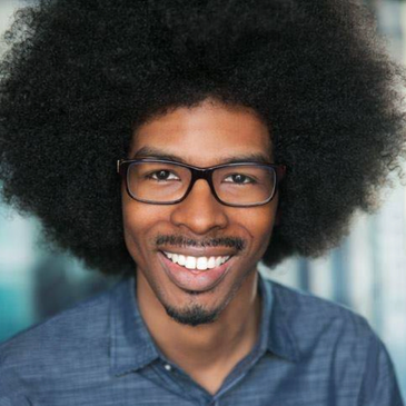 Jeffrey Thompson African American Man large afro black glasses gray shirt with goatee