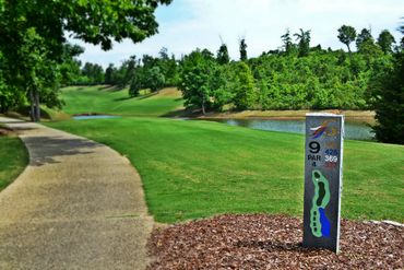 Gunter's Landing golf course hole 9 marker beside a green fairway and water hazard.
