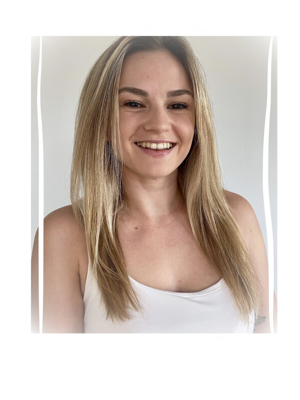 Smiling young woman with long blonde hair in a white top.