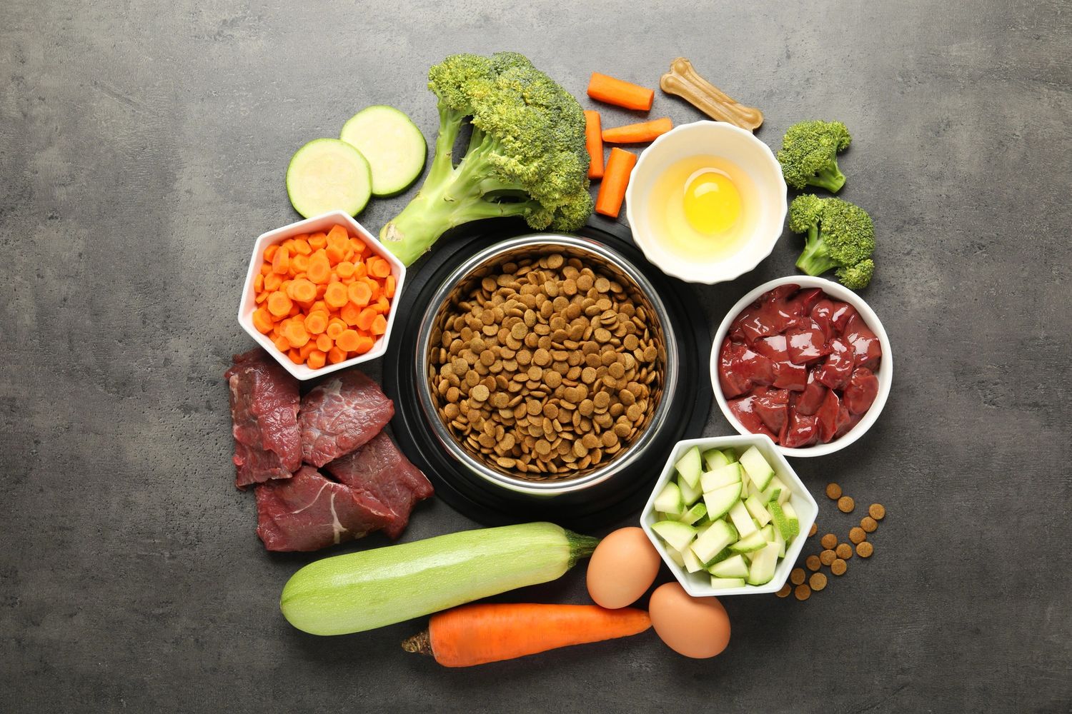 Healthy dog food ingredients including vegetables, meat, eggs, and dry kibble.