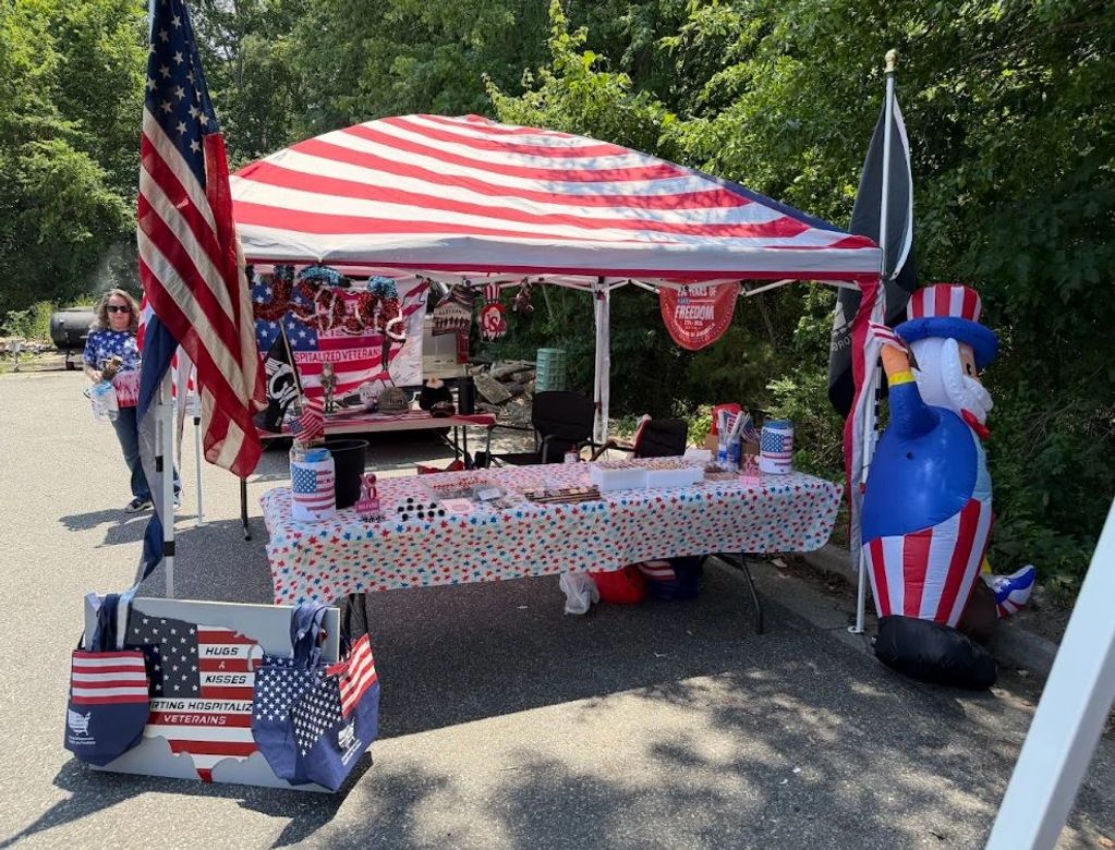 Patriotic booth with American flags and decorations supporting hospitalized veterans.