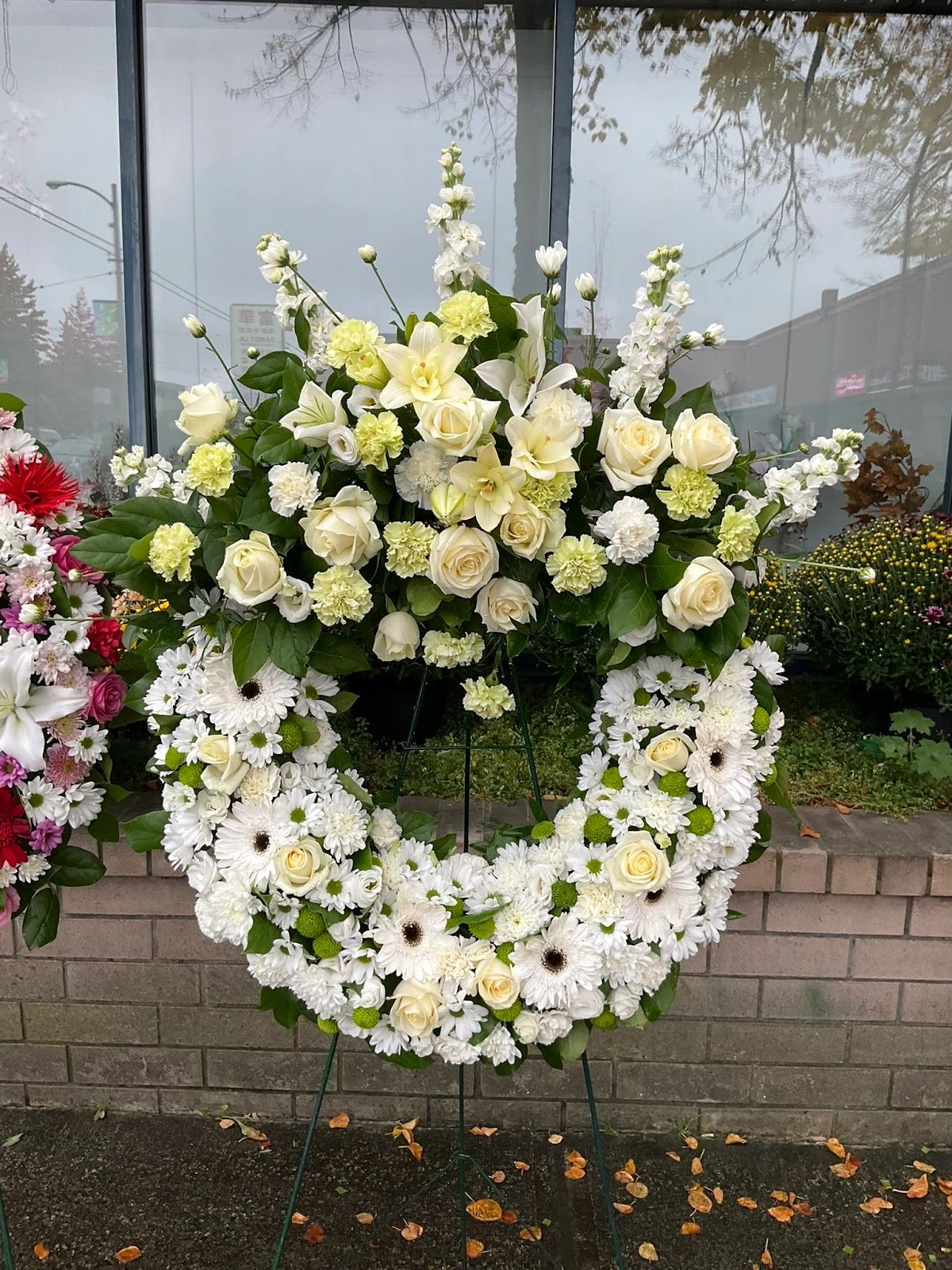 Elegant white and cream floral wreath on display outdoor.
