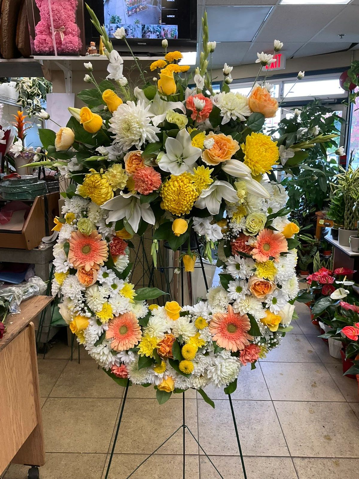 Colorful floral wreath with yellow, white, and pink flowers.