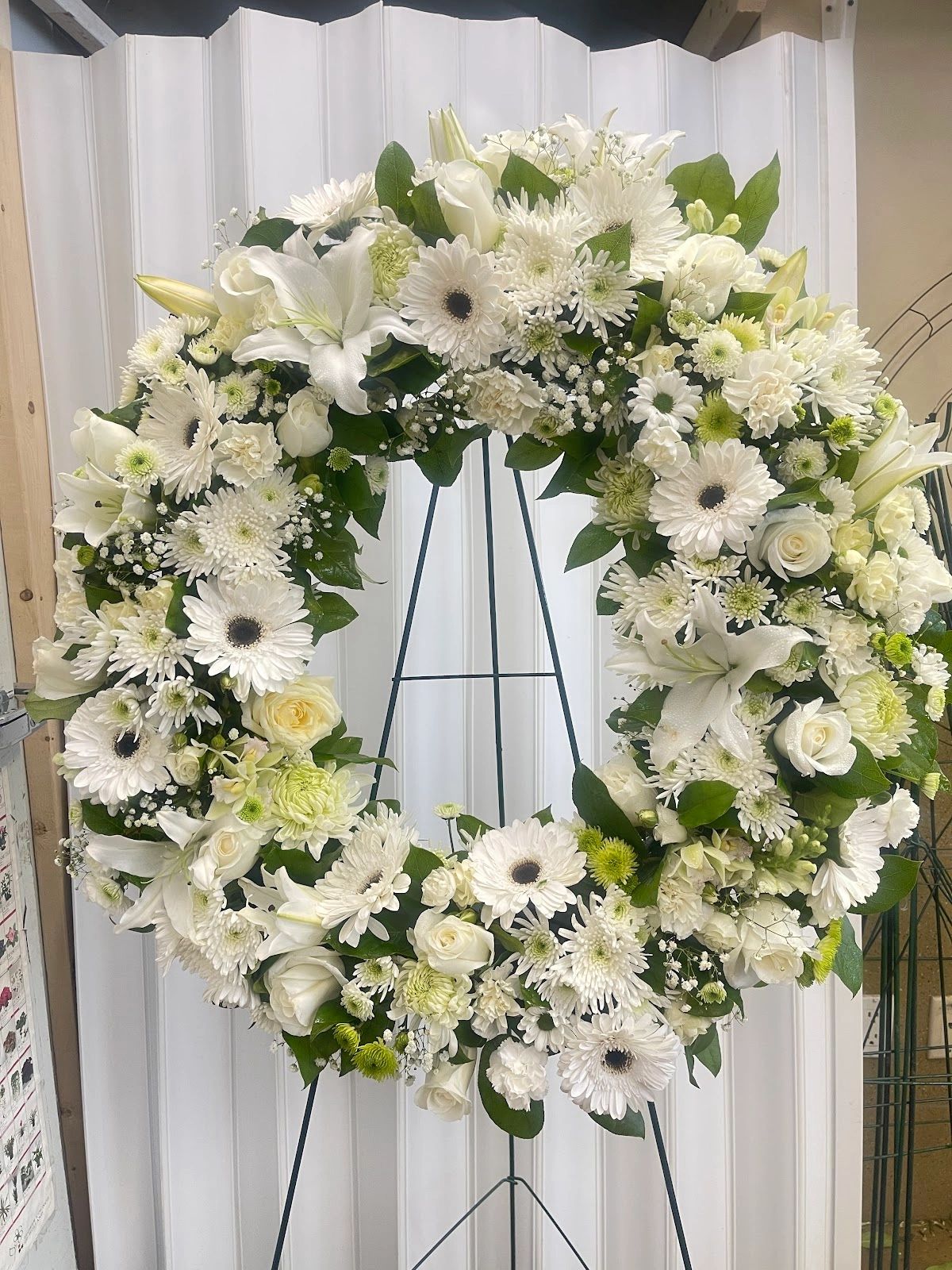 Elegant white floral wreath on a stand.