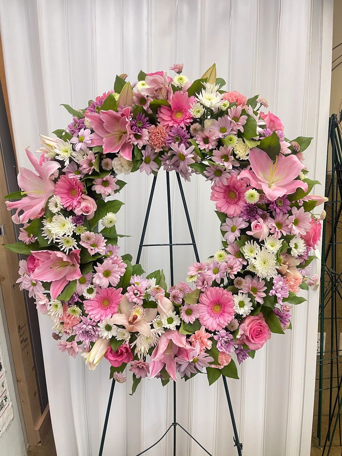 Beautiful pink and white floral wreath on a stand.
