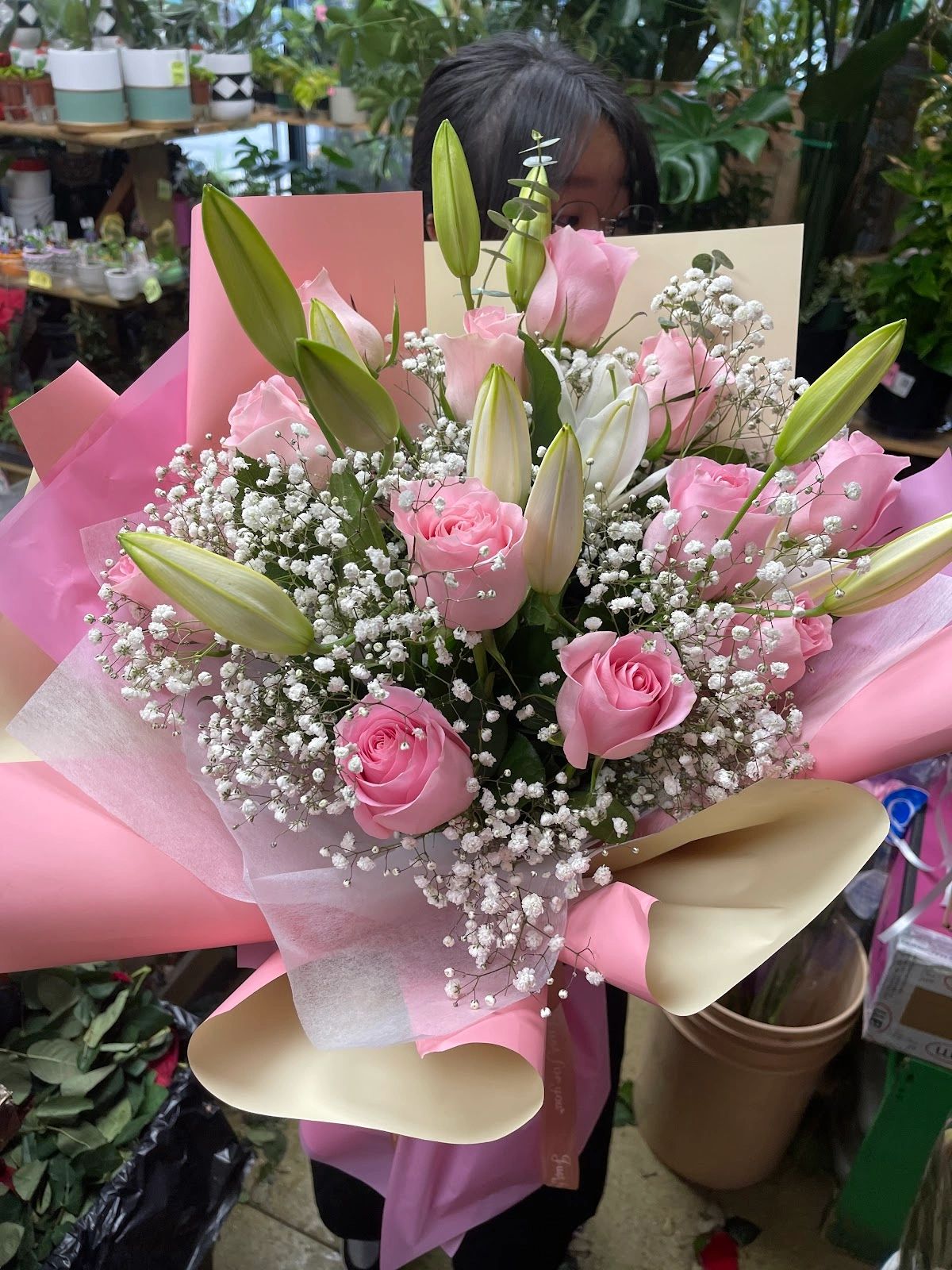Bouquet of pink roses and white lilies with baby's breath.