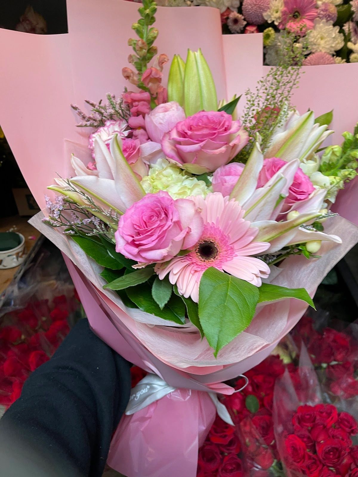 Pink and white floral bouquet wrapped in pink paper.