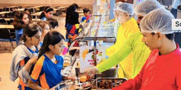 Students in line at a cafeteria food counter.