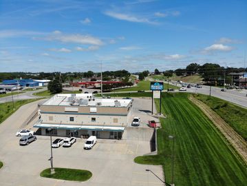 Aerial view of Hickory Plaza with parking lot and nearby roads under a clear blue sky.