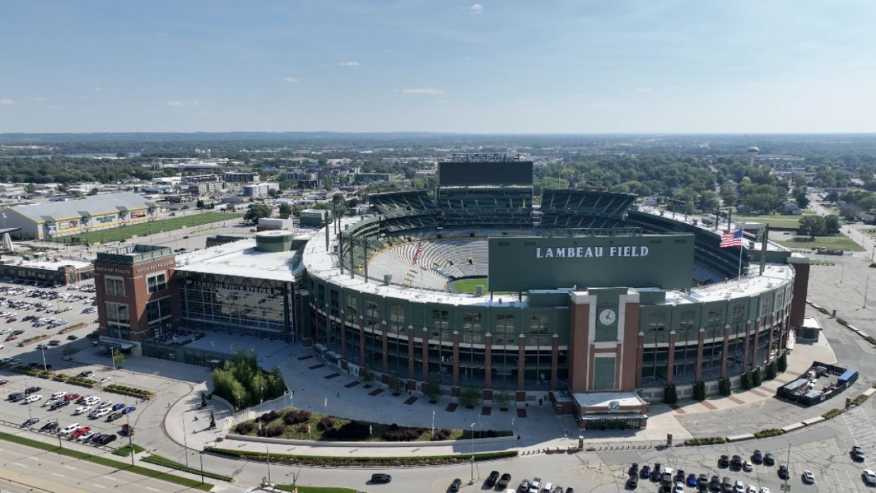 Aerial view of Lambeau Field stadium in a cityscape.