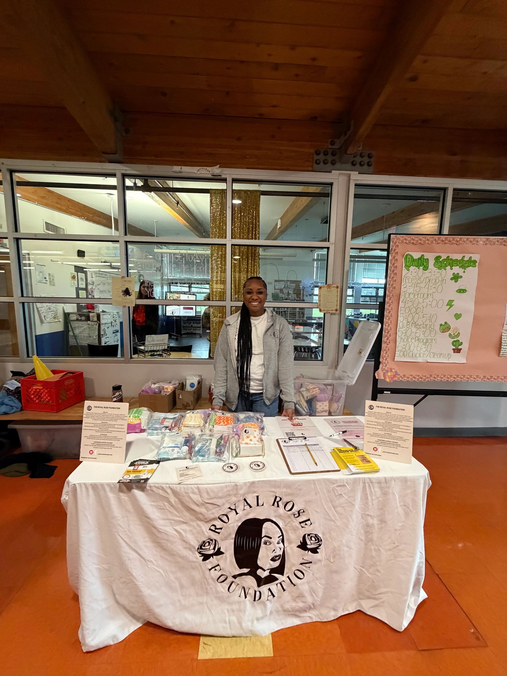 Woman stands behind a charity booth with hygiene products.