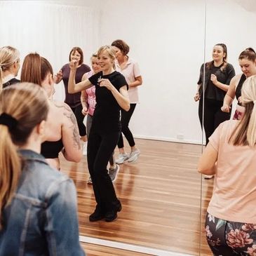 Group of ladies dancing and smiling.