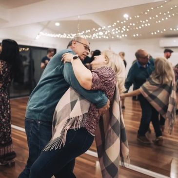 A couple dancing under fairy lights.