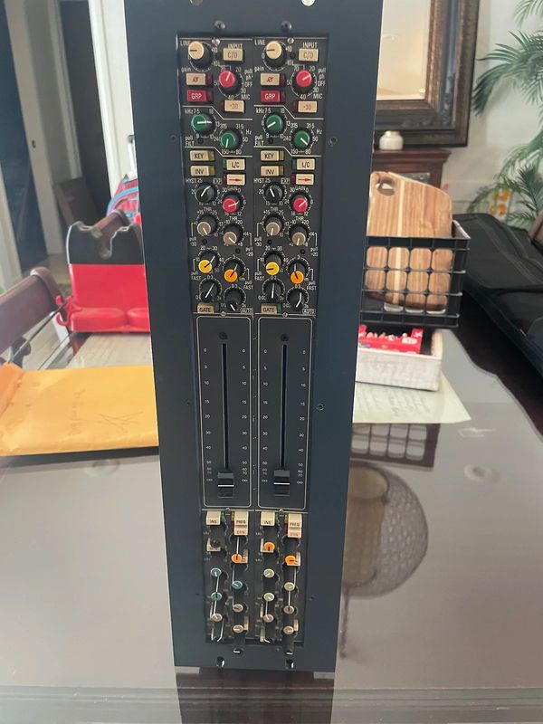 Close-up of a professional audio mixer with multiple knobs and sliders.
