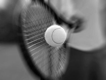 Close-up of a tennis ball hitting the racket strings.