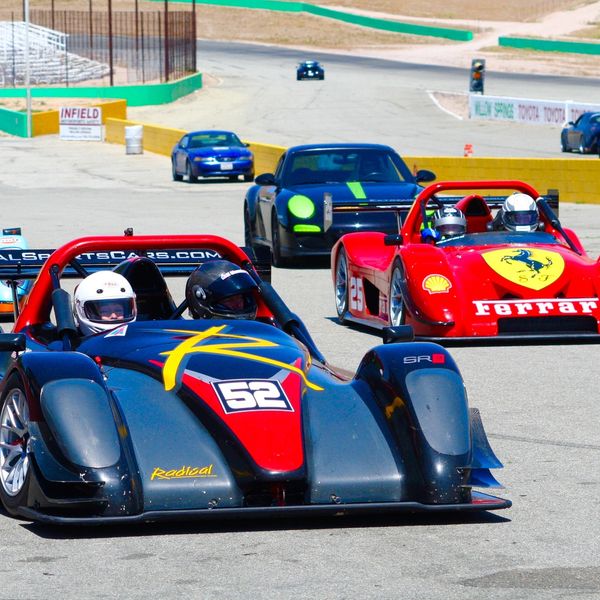 Group of Radicals and various cars getting ready to go on track