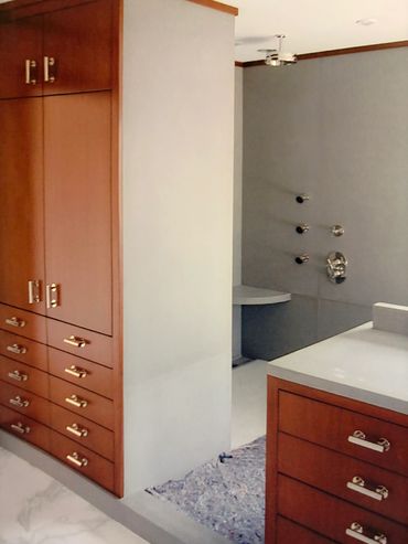 Modern bathroom with wood cabinets and marble floors.