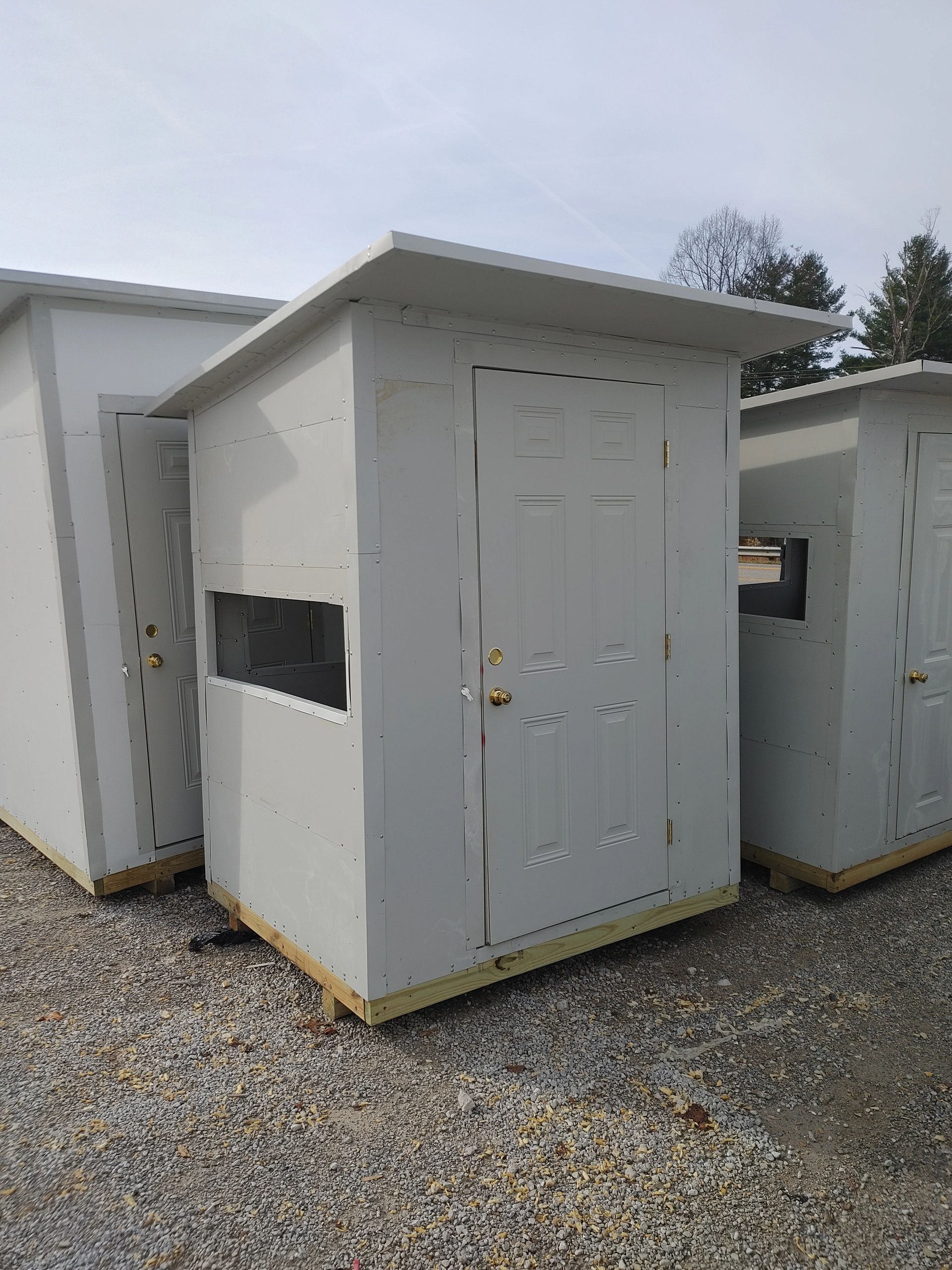 Small grey sheds with paneled doors and windows.