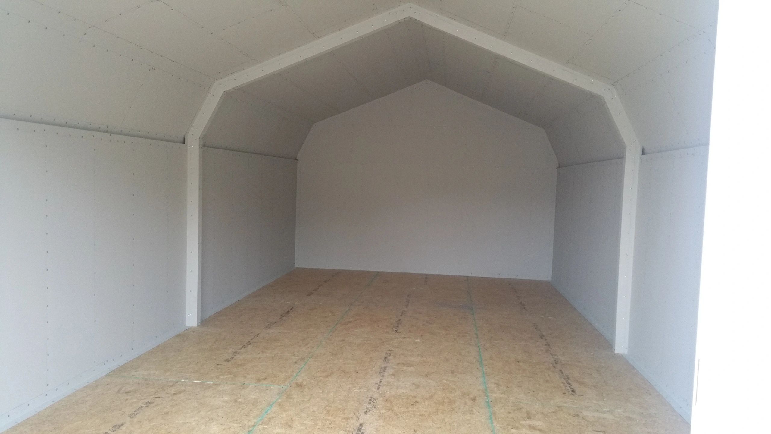 Empty interior space with white walls and wooden floor.