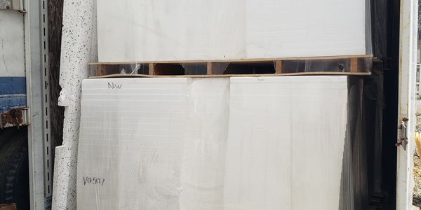 Large white slab tiles stored vertically.