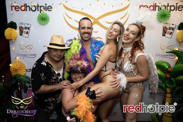 Group of people in festive costumes posing playfully at a party.
