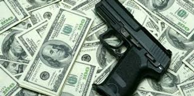 A gun placed on a pile of hundred-dollar bills.