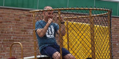 Man sitting in a dunk tank, ready to be dunked.