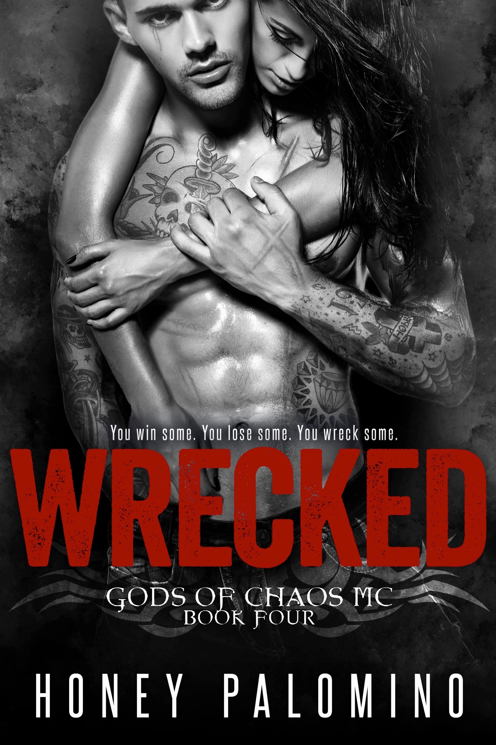 Tattooed couple embrace intensely in black and white.