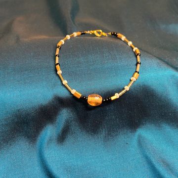Sulafat star anklet on a blue background