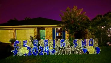 Yard sign celebrating Clear Springs senior Sariya, class of 2024, at night.