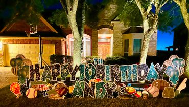 Outdoor nighttime birthday display with lights and decorations.
