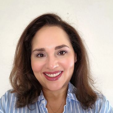 Smiling woman with shoulder-length brown hair and striped blue shirt.