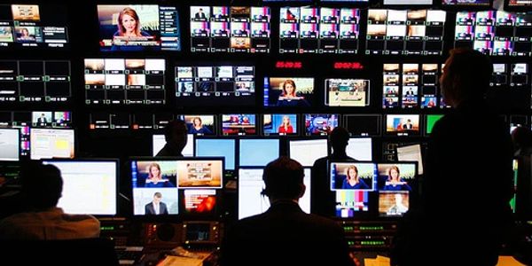 Control room with multiple monitors and operators.