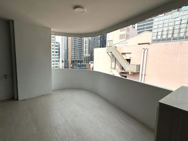 Empty balcony with city buildings view and neutral tones.