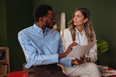 Two colleagues discussing a document in an office.