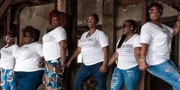 Six women wearing white shirts and sunglasses posing together.