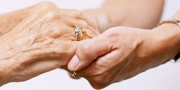 Elder and young person holding hands