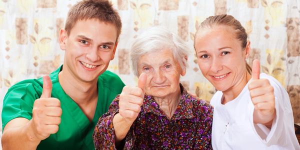 Elder and her carers smiling at the camera