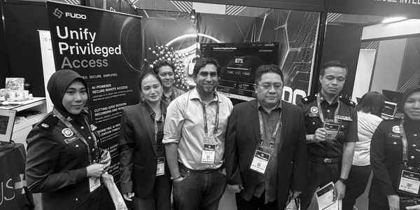 Group of professionals at FUDO booth showcasing privileged access solutions.