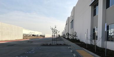 Empty parking lot next to a modern industrial building.