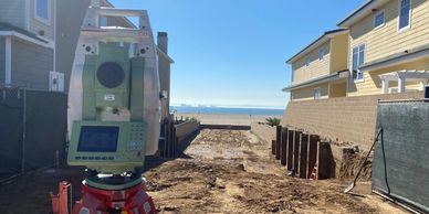 A surveying instrument on a construction site near the beach.