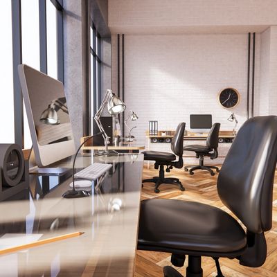 office space with two desks with computers, glass desk and three office chairs. 