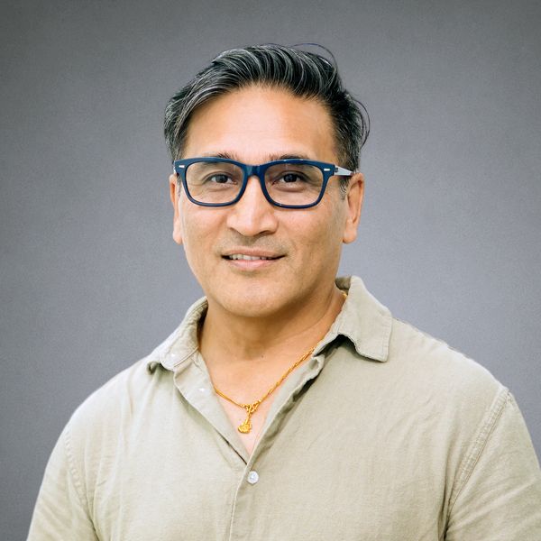 Middle-aged man with black hair and glasses.