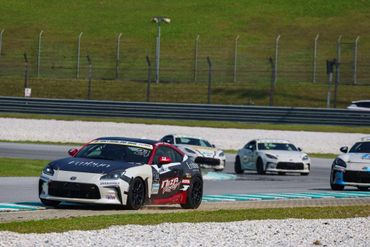 Race cars speeding on a track during a competitive event.