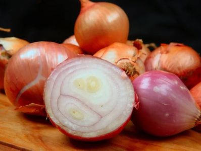 Various onions, one halved showing inner rings.