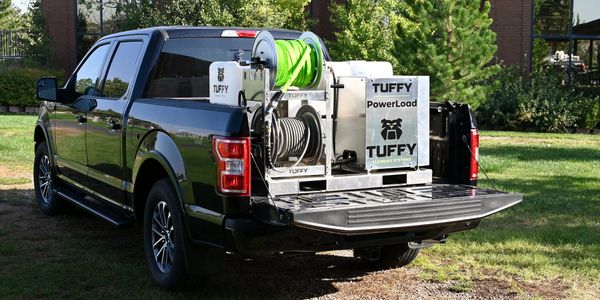 Black pickup truck with the Tuffy Cold Water Tank Skid sitting in back of the truck bed. 