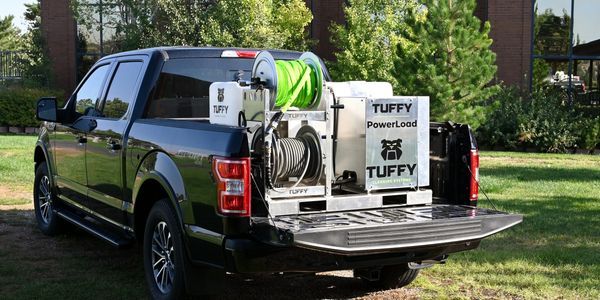 Black pickup truck with the Tuffy Cold Water Tank Skid sitting in back of the truck bed. 