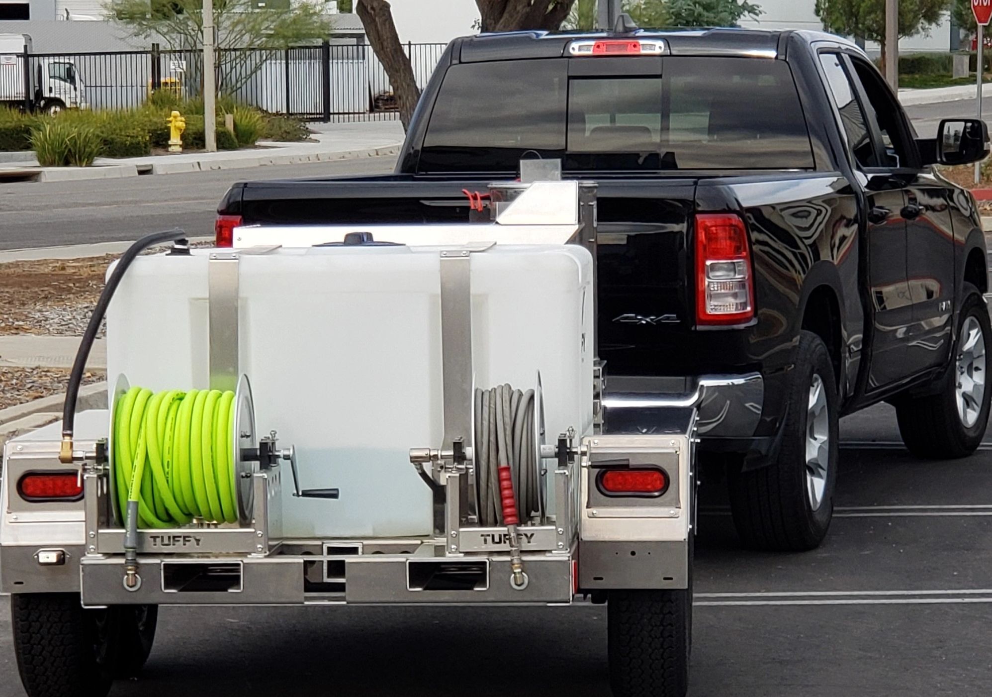 View of a black truck hauling a Tuffy PowerLoad from behind. 