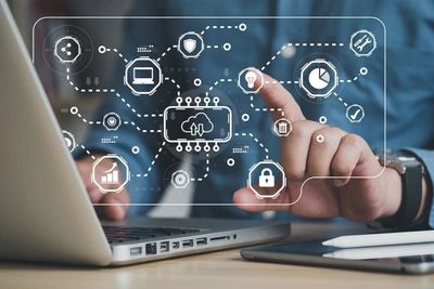 Person interacting with virtual cloud computing and data security icons over a laptop.