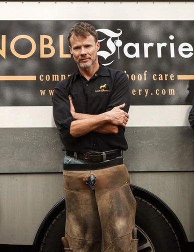 Confident man in work attire stands in front of a company sign.